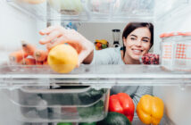 Kvinde tager en citron i et Electrolux køleskab