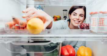 Kvinde tager en citron i et Electrolux køleskab